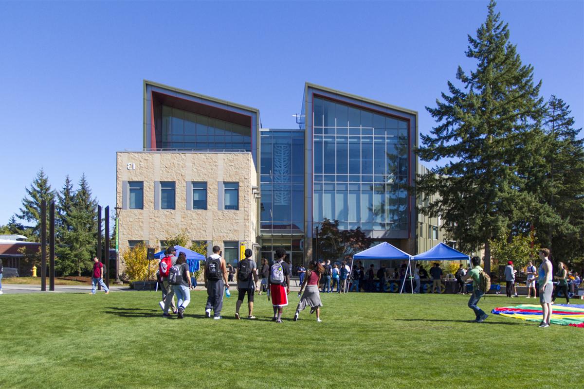 A group of students walking across the campus commons toward Building 13